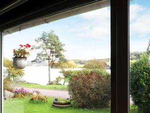 una finestra con vista su un cortile e un vaso di fiori di 4 person holiday home in VESSIGEBRO a Vessigebro