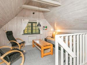 Øhuseにある6 person holiday home in Ulfborgのベッド、テーブル、椅子が備わる屋根裏部屋です。