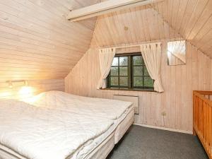 a bedroom with a bed in a room with a window at 6 person holiday home in Ulfborg in Øhuse