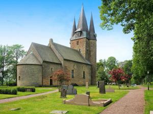 eine alte Kirche mit einem Uhrturm auf einem Friedhof in der Unterkunft 4 person holiday home in G TENE in Götene