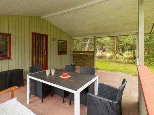 a porch with a table and chairs on a patio at 6 person holiday home in R dby in Rødby