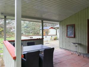 a patio with a wooden table and chairs at 6 person holiday home in R dby in Rødby
