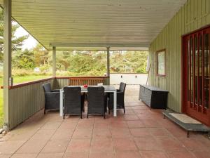 a patio with a table and chairs on it at 6 person holiday home in R dby in Rødby