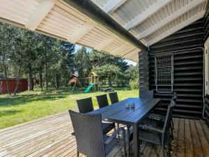 a patio with a table and chairs on a deck at 6 person holiday home in R dby in Rødby