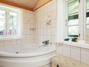 a bathroom with a tub and a window at 6 person holiday home in R dby in Rødby