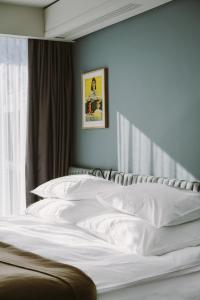 een slaapkamer met een bed met witte lakens en een raam bij PURO Wrocław Stare Miasto in Wrocław
