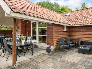 a patio with a table and chairs in front of a house at 5 person holiday home in Middelfart in Middelfart