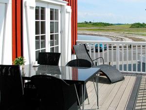 una mesa y sillas en un porche con vistas al océano en 6 person holiday home in Bagenkop, en Bagenkop