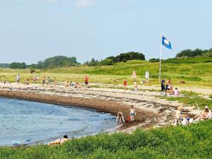 un grupo de personas en una playa con bandera azul en 6 person holiday home in Bagenkop, en Bagenkop