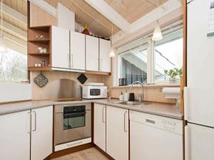 a kitchen with white cabinets and a sink at 6 person holiday home in Ebeltoft in Ebeltoft