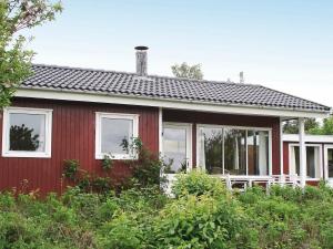 VordingborgにあるTwo-Bedroom Holiday home in Vordingborg 1の白窓・茂みのある赤い家