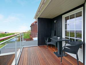 a balcony with a table and chairs on a deck at 6 person holiday home in Hemmet in Falen