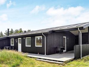 a black tiny house with a deck at 6 person holiday home in Fan in Sønderho