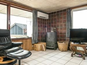 - un salon avec une chaise et une cuisinière dans l'établissement 6 person holiday home in R m, à Lakolk