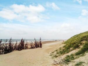 a sandy beach with people walking on the beach at 7 person holiday home in Harbo re in Harboør
