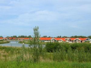 een rij huizen met rode daken naast een rivier bij 12 person holiday home in Otterndorf in Otterndorf