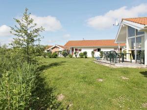 einen Hof mit einem Tisch und Stühlen auf einem Haus in der Unterkunft 5 person holiday home in Otterndorf in Otterndorf