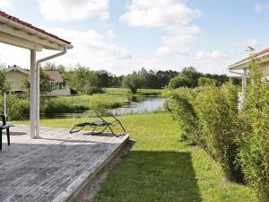 a wooden deck with a view of a pond at 5 person holiday home in Otterndorf in Otterndorf