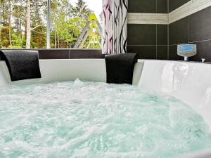 La salle de bains est pourvue d'une baignoire remplie d'eau. dans l'établissement 24 person holiday home in Frederiksv rk, à Frederiksværk