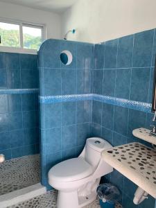 uma casa de banho em azulejos azuis com um WC e um lavatório em Hotel Real Da Vinci em Acapulco
