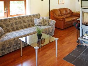 - un salon avec un canapé et une table en verre dans l'établissement 6 person holiday home in L kken, à Løkken