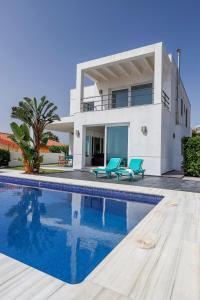 a villa with a swimming pool in front of a house at Cádiz punta carnero 1 in Algeciras