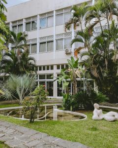 a teddy bear sitting in the grass in front of a building at Hotel Cataguases in Cataguases