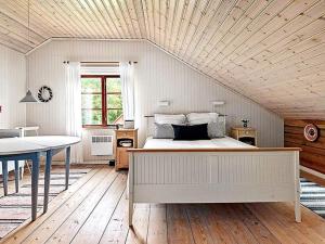 ein Schlafzimmer mit einem Bett und einem Tisch darin in der Unterkunft Holiday home SKILLINGARYD in Skillingaryd