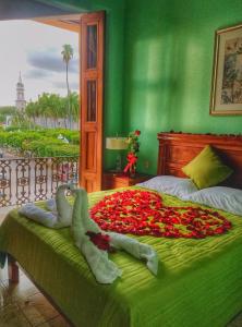 ein grünes Schlafzimmer mit einem Bett mit Blumen in der Unterkunft Hotel Santa Elena in El Fuerte