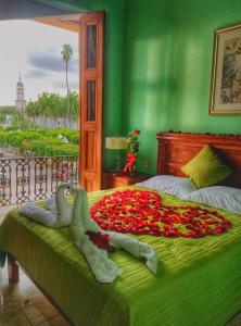 Un dormitorio verde con una cama cubierta de flores. en Hotel Santa Elena, en El Fuerte