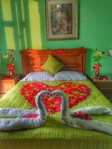 two swans laying on a bed covered in flowers at Hotel Santa Elena in El Fuerte