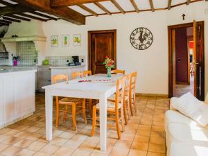 una cucina e una sala da pranzo con tavolo e sedie bianchi di Appealing villa in Bi vre with garden a Bièvre