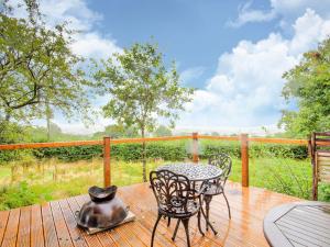 a table and chairs on a deck with a tea kettle at Vintage Holiday home in Welshpool with Garden in Welshpool