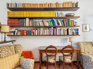 a room with a table and chairs and bookshelves at Belvilla by OYO Belle Epoque in Meina