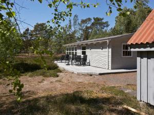 un edificio con un porche con sillas. en 4 person holiday home in Nex en Neksø