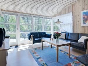 ein Wohnzimmer mit einem Sofa und einem Tisch in der Unterkunft 4 person holiday home in Nex in Neksø