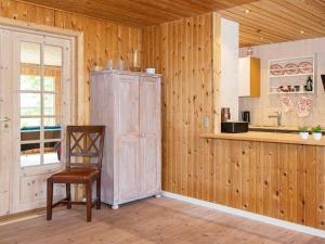 eine Küche mit einem Stuhl und einer Holzwand in der Unterkunft 6 person holiday home in Glesborg in Glesborg