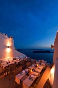 a restaurant with tables and chairs at night at Kapari Natural Resort in Imerovigli