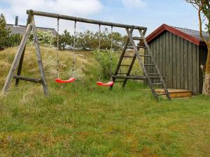 an old swing set with two swings in a yard at 4 person holiday home in Fan in Fanø