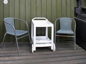 2 chaises et une table et des chaises blanches sur une terrasse couverte dans l'établissement 4 person holiday home in Fan, à Fanø