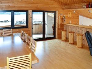 a room with a table and chairs in a cabin at 10 person holiday home in EIDSVÅG-By Traum in Rød