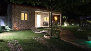 dom ze stołem i krzesłami na dziedzińcu w nocy w obiekcie Costa Petra - Luxury Seaside Cottage with Garden - Vacation House for families in Greece w mieście Nea Mesangala