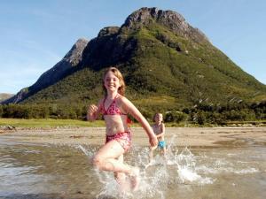 zwei Kinder spielen im Wasser am Strand in der Unterkunft 5 person holiday home in ENGAV GEN in Åmnes