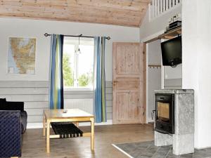 een woonkamer met een open haard en een televisie bij 6 person holiday home in LJUNG in Alboga