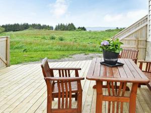 a wooden table with two chairs and a potted plant on a deck at 11 person holiday home in Fj rtoft in Fjørtoft