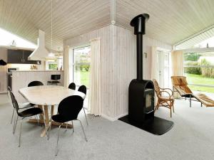 a kitchen and dining room with a wood stove in a room at Three-Bedroom Holiday home in Hejls 7 in Hejls