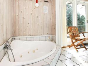 a bath tub in a bathroom with a chair at 8 person holiday home in L s in Læsø