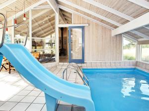 una piscina con un tobogán azul en una casa en 8 person holiday home in L s, en Læsø