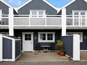 a black house with a white balcony and a table at 4 person holiday home in Blåvand-By Traum in Blåvand