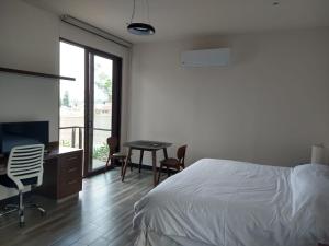 a bedroom with a bed and a desk and a television at Suite Loft Deslumbrante Salida a México 102A in Querétaro